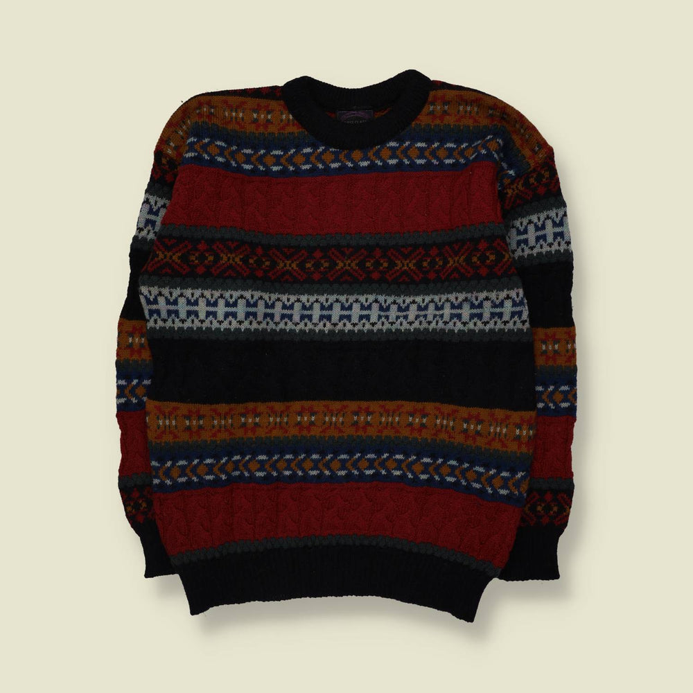 A long-sleeve crewneck knit sweater with horizontal Fair Isle style patterns in red, black, navy blue, rust orange, and cream, laid flat against a light beige background.